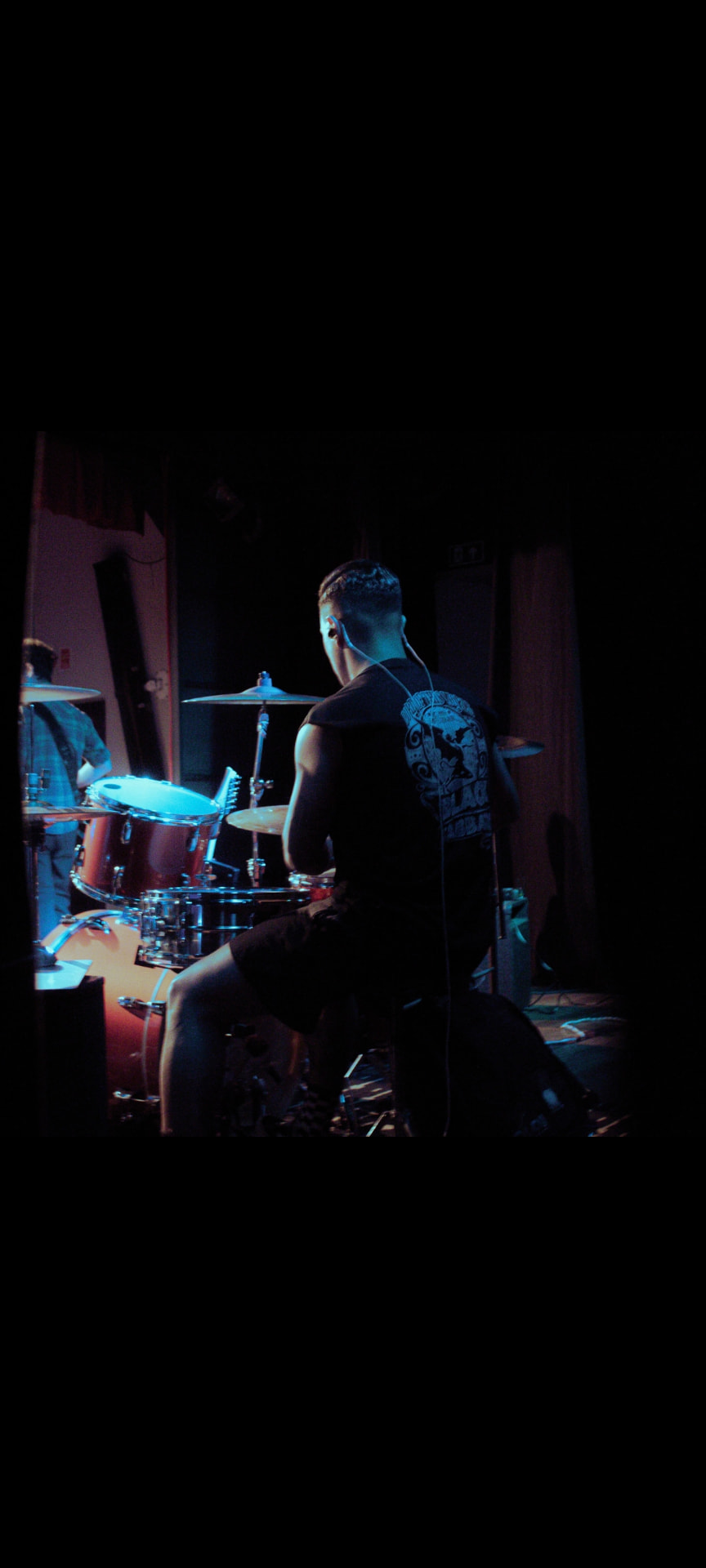 Jhoow Batera, músico e baterista, tocando bateria em um palco